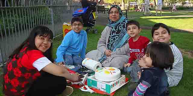 Dr Sabah Usmani, 44, and her five children: Hira, 12, Sohaib, 11, Muneeb, nine, Rayyan, six, and Maheen, three sit in a park with a celebration cake