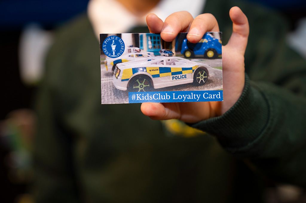 School pupil holding kids club loyalty card