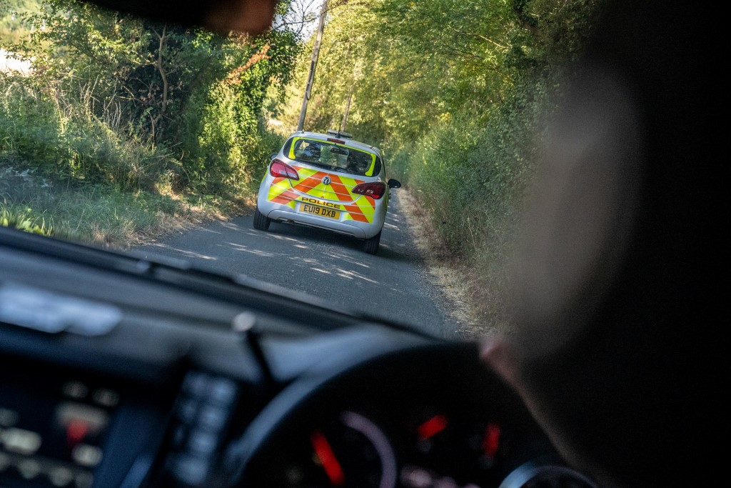Driver's view of police vehicle on country lane