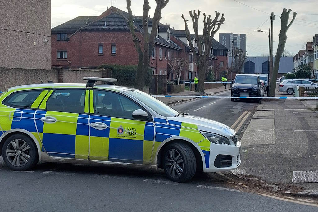 Police car in foreground and police cordon in background