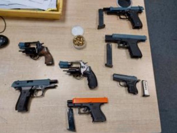 A number of blank firing handguns laid out on a table