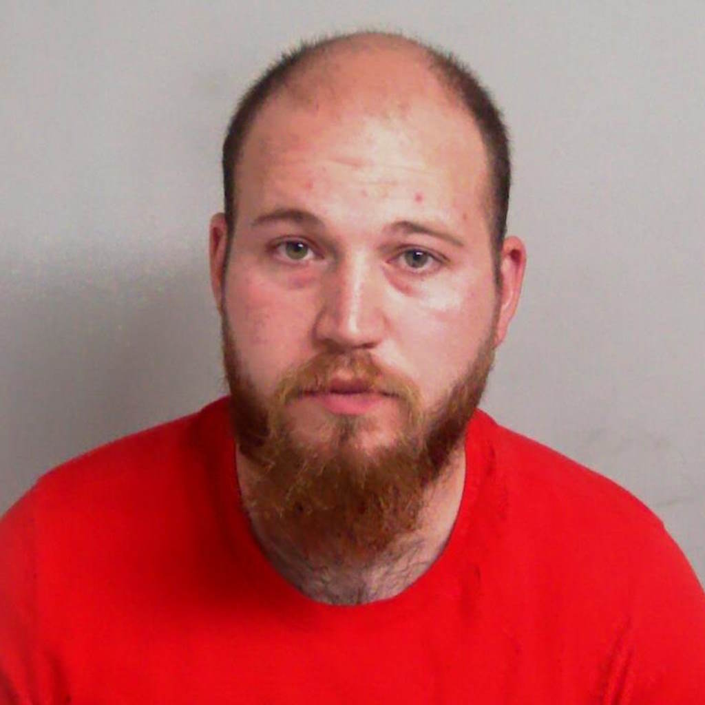 Custody image shows bearded man in red shirt