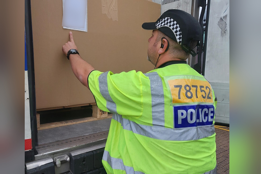 A uniformed Essex Police rural engagement officer opens the back of a lorry at a port