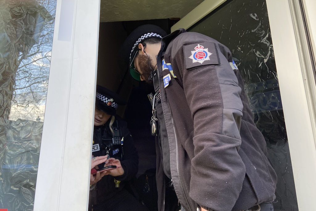 Two uniformed Essex Police local policing officers speak to a householder at the front door