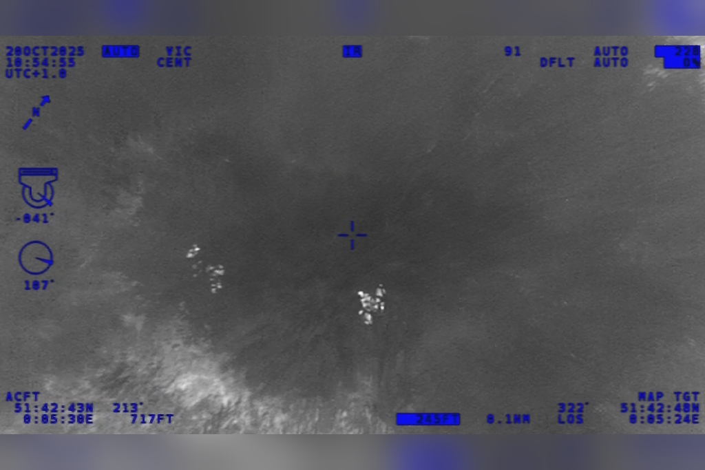 A screenshot of infra-red footage from a National Police Air Service helicopter  showing four people hiding in woodland
