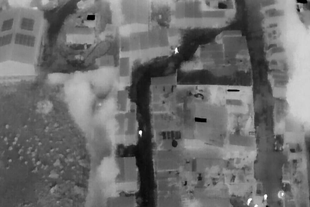 Black and white aerial picture from drone of foot chase