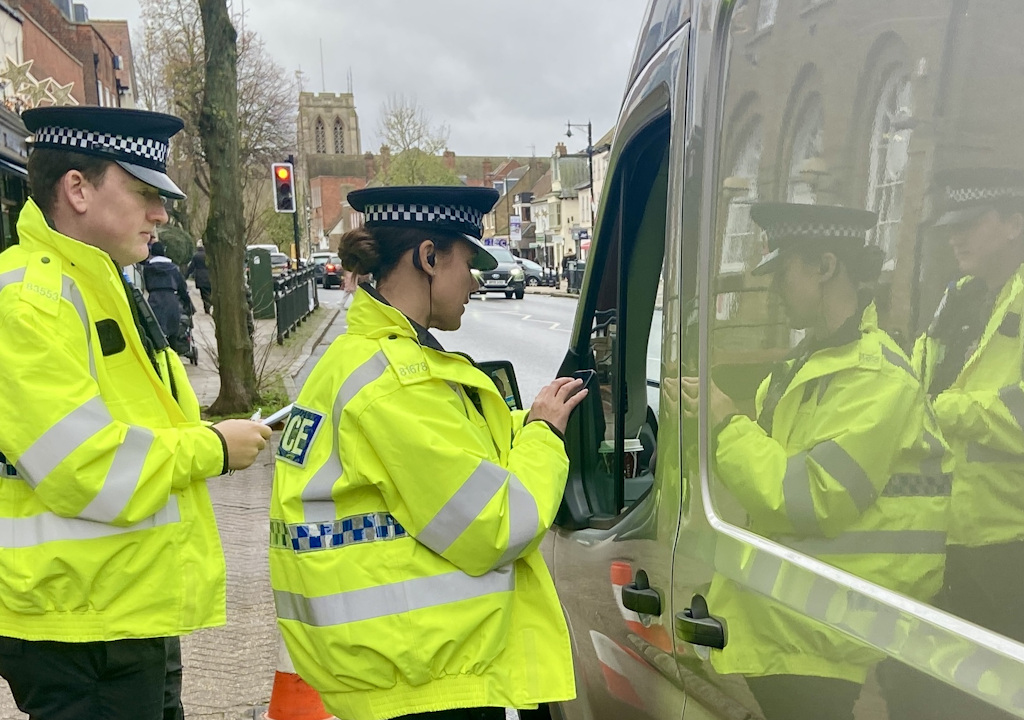 Two officers at a van window in Epping.
