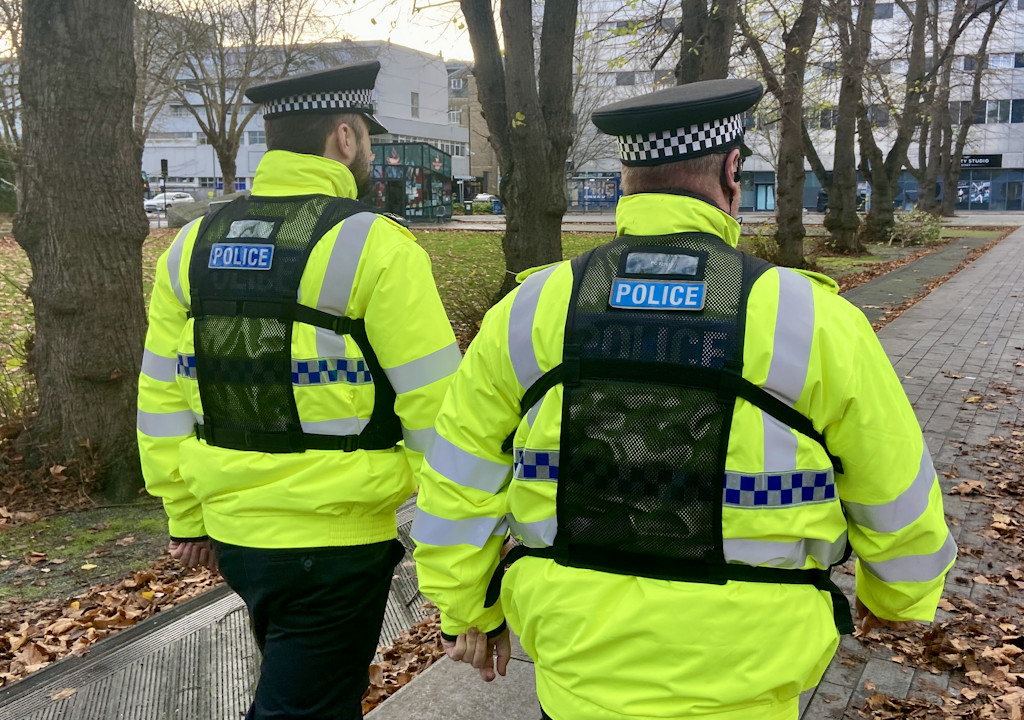 Two uniformed officers in yellow high viz on patrol