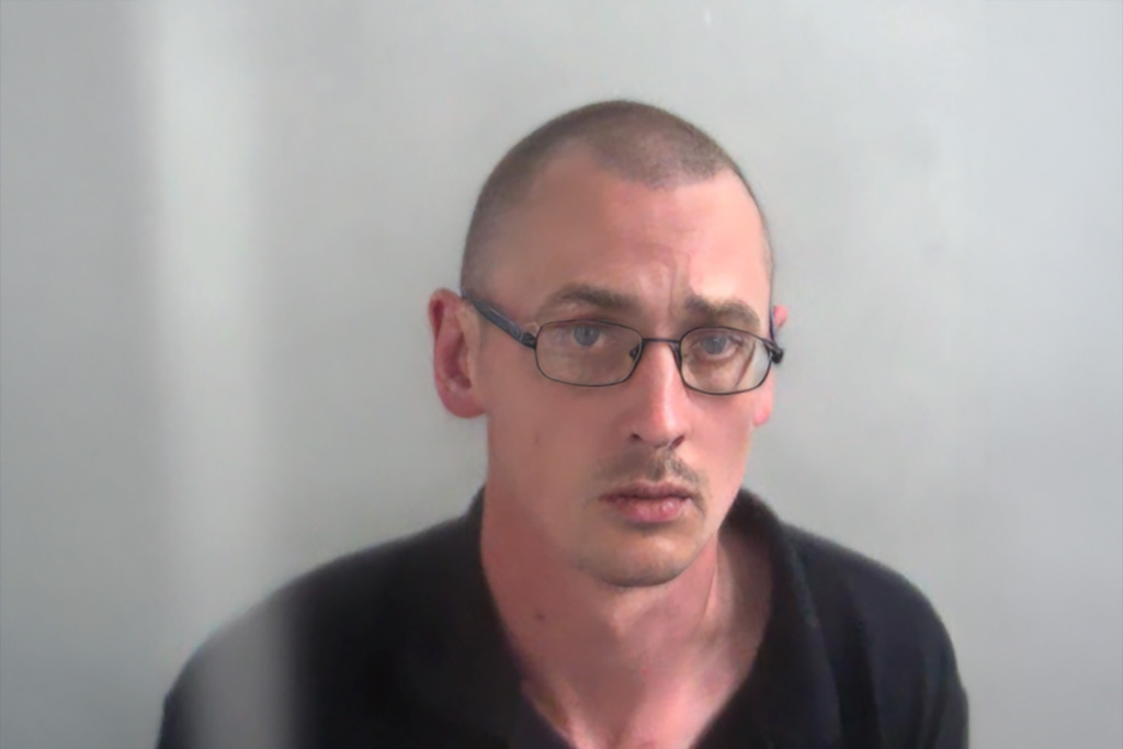 Man with shaved head, glasses