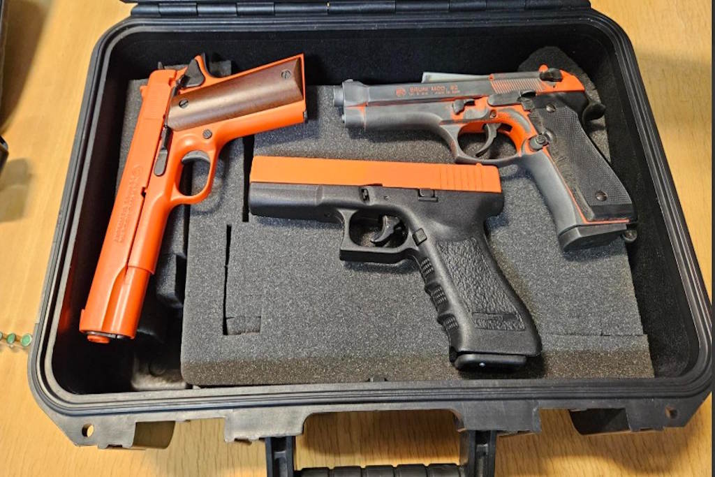 Three blank firing Bruni guns - they are orange and black and placed in a gun case