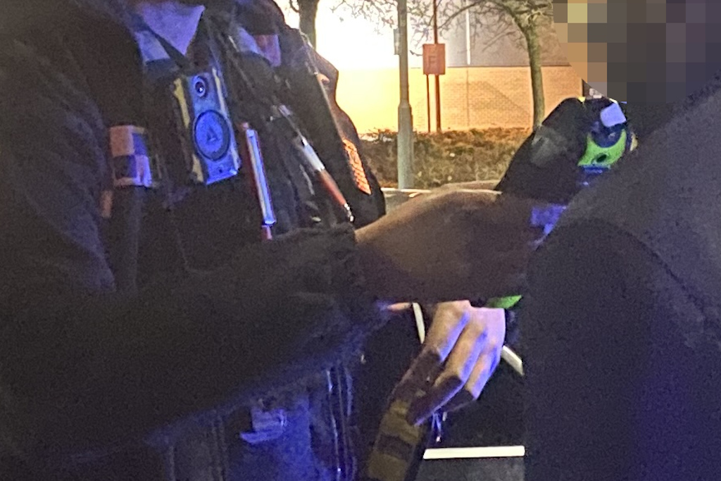 A uniformed Essex Police officer breath tests a motorist in the dark