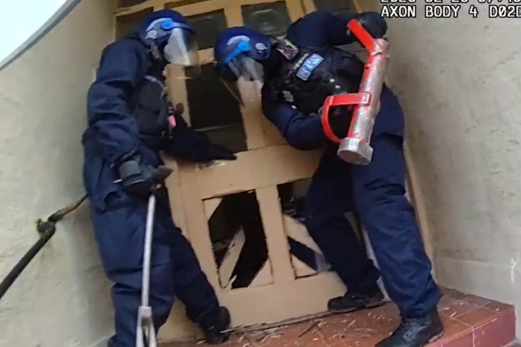 Two officers using a ram to enter a door