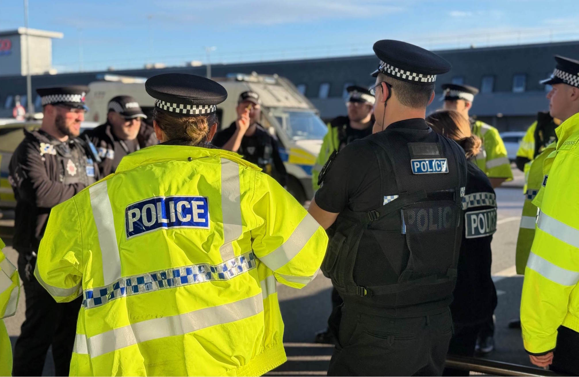 Officers gathered in a group in uniform and high viz