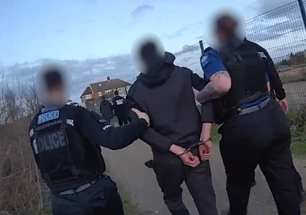 A boy is led away after being arrested.
