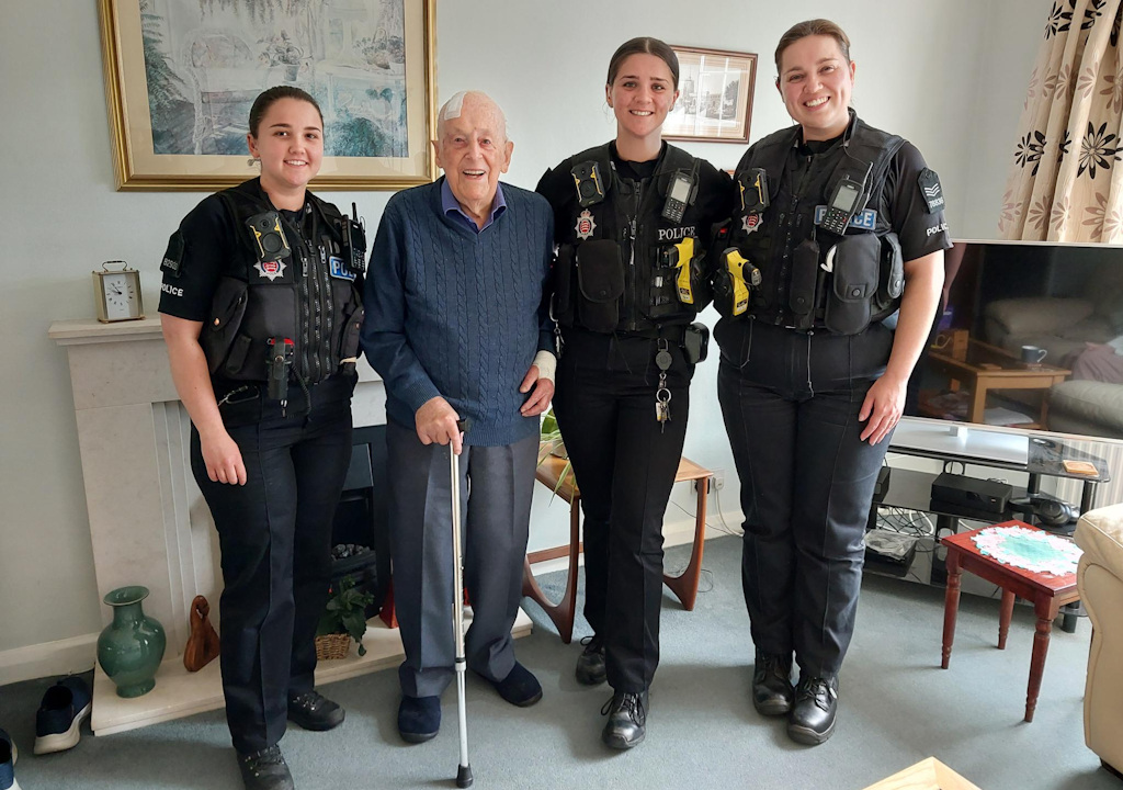 Three police officers and Roy Knights in his living room.