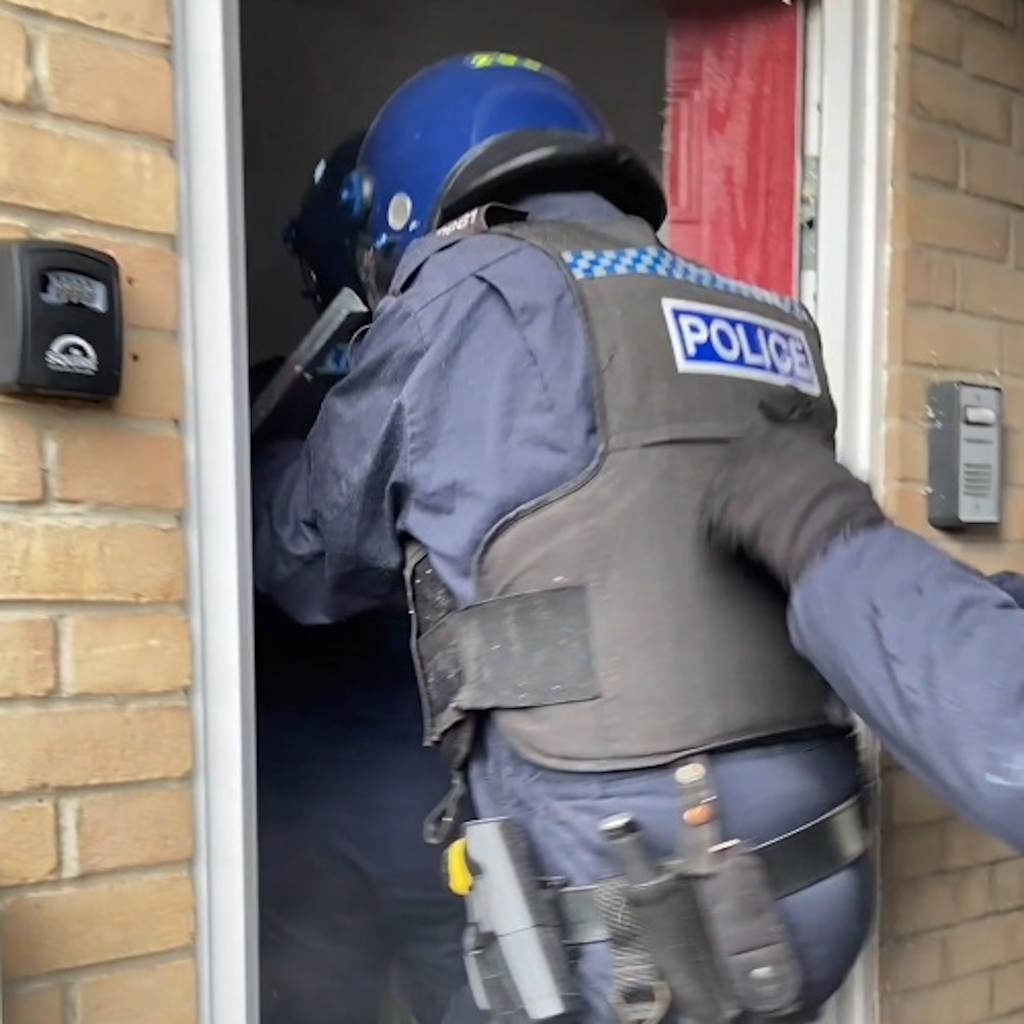 An officer in full gear enters a property