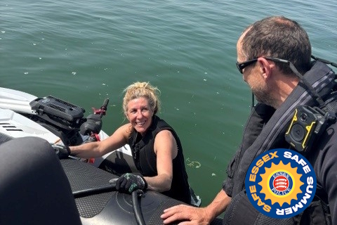 A uniformed Essex Police marine officer patrolling on a rigid-hulled inflatable boat, or rib, speaks to a personal watercraft rider
