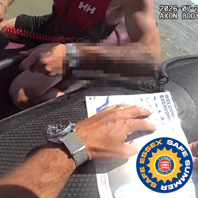A first-person view from an Essex Police body-worn video camera showing a marine officer holding a police form while on the force's rigid-hulled inflatable boat, or rib, Sentinel. There is also a partial view of a man on a personal watercraft, who is holding on to the side of the boat