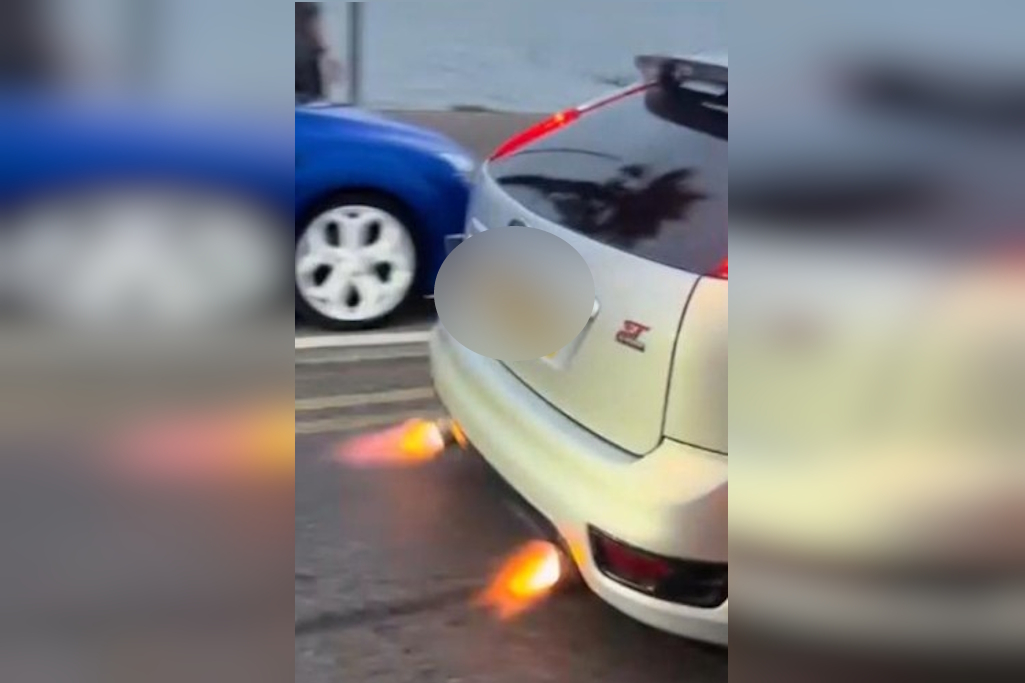Flames exiting car exhaust as it drives