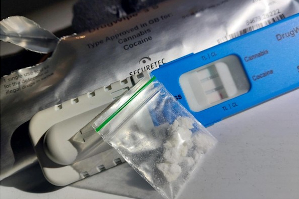 Drugs in plastic pouch in front of drugs wipe test