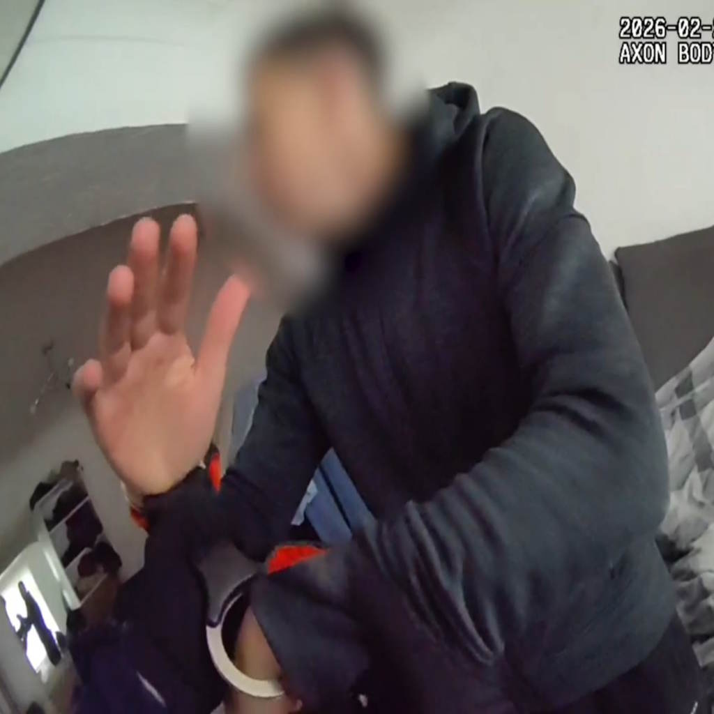 A man in dark clothing in handcuffs